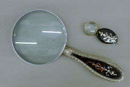 A silver and tortoiseshell handled magnifying glass, and a tortoiseshell loupe.