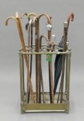 A Victorian brass stick stand containing a collection of walking sticks. 45 cm wide.