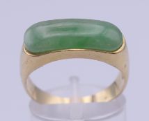 A 14 K gold and jade ring. Ring size Q/R. 4.1 grammes total weight.