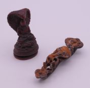 Two small Chinese wood carvings, one of a seated Buddha on a coiled cobra, the other a ruyi sceptre.