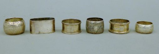 Five silver napkin rings (156.9 grammes) and an Eastern unmarked white metal napkin ring.