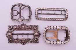 A silver buckle and three white metal and clear stone buckles. Silver buckle 8.5 x 5.5 cm.