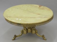 An onyx-topped coffee table. 85 cm diameter.