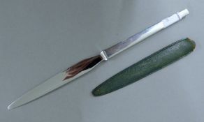 A Georg Jensen silver handled letter opener in leather sheath. 22.5 cm long.