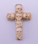 A bone cross carved with skulls. 7 cm high.