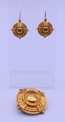 An unmarked yellow metal Etruscan revival mourning brooch and a pair of matching earrings, boxed.