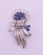 A platinum, sapphire and diamond spray brooch together with a 2000 Insurance Valuation. 4.