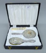 A cased part silver dressing table set. The case 30 cm wide.