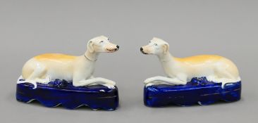 A pair of Staffordshire pottery recumbent greyhound inkwells, circa 1850. Each 19 cm long.