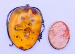 A white metal mounted large pendant and a cameo brooch. Amber 7 cm high, cameo 4.5 cm high.