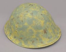 A British WWII camouflage tin helmet with liner. 27 5 cm wide.