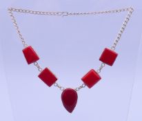 A silver a large red stone necklace. 41 cm long, central pendant 3.5 cm high.