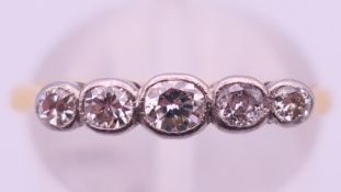 An 18 ct gold and platinum five-stone diamond ring. Ring size N/O. 2.1 grammes total weight.