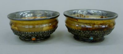 Two Eastern unmarked silver-mounted bowls. Each 11 cm diameter.