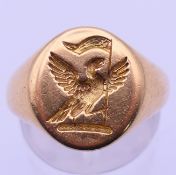 An 18 ct gold signet ring with phoenix crest. Ring size N/O. 12.9 grammes.