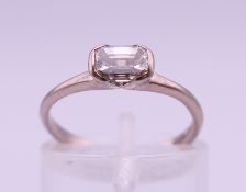 An 18 ct white gold .50 carat emerald-cut diamond ring. Ring size I. 2.1 grammes total weight.