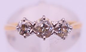 An 18 ct gold and diamond three-stone ring. Ring size L. 2.1 grammes total weight.