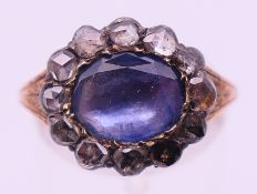 An unmarked gold, diamond and lilac stone ring. Ring size O. 3.6 grammes total weight.