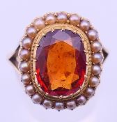 An unmarked gold, topaz and pearl ring. Ring size P/Q. 6.8 grammes total weight.
