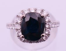 An 18 ct white gold, natural sapphire and diamond ring with diamond shoulders,