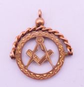 A 9 ct gold Masonic fob pendant. 2.5 cm high including suspension loop. 2.4 grammes.