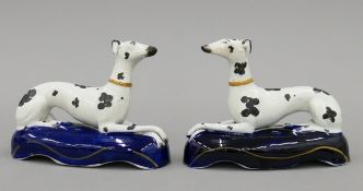 A pair of Staffordshire pottery recumbent greyhound inkwells, circa 1860. Each 16 cm wide.