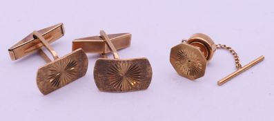 A pair of 9 ct gold cufflinks and a similar 9 ct gold tie pin. Cufflink 1.7 x 1 cm. 8.
