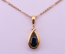 A 9 ct gold, diamond and sapphire pendant on a 9 ct gold chain. Pendant 1.