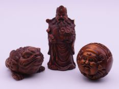 Three wooden carvings (a toad, a two-faced ball and a deity). Deity 7.5 cm high.