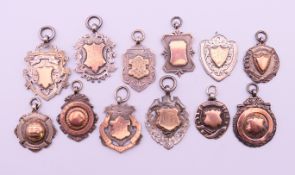 Twelve silver and gold fobs mostly sporting related, football, cricket, etc.