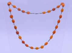 A silver and amber bead necklace. 50 cm long. 12.9 grammes total weight.