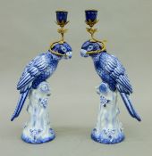 A pair of gilt metal-mounted blue and white porcelain parrot-form candlesticks. Each 36 cm high.