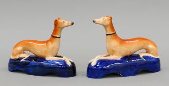A pair of Staffordshire pottery recumbent greyhound inkwells, circa 1860. Each 18 cm long.