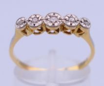 An 18 ct gold five-stone diamond ring. Ring size Q. 2.4 grammes total weight.