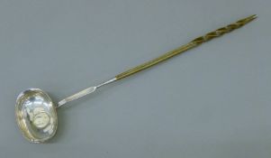 A Georgian unmarked silver baleen-handled toddy ladle, the bowl set with a coin. 37.5 cm long.