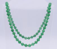 A jade bead necklace. Approximately 66 cm long, beads approximately 1 cm diameter.