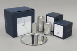 Three boxed Georg Jensen stainless steel candlesticks. The largest 12 cm high.