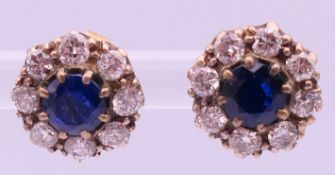 A pair of 9 ct gold, sapphire and diamond earrings. 1 cm diameter.