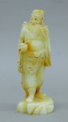 A Chinese carved stone deity. 20 cm high.