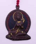A Tibetan bronze pendant depicting Tara. 9 cm high.