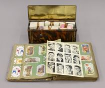 A collection of vintage cigarette cards, some in an album, some loose. The album 18 cm wide.