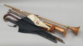 A quantity of coaching horns, parasols, etc. The largest horn 115 cm long.