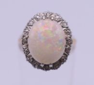 A 9 ct gold, opal and diamond ring. Ring setting 1.6 cm high, ring size M/N. 3.