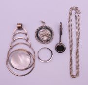 A silver chain, a silver modernist pendant, a silver ring,