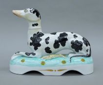 A circa 1845 large Staffordshire porcelain Disraeli coursing greyhound. 27 cm long.