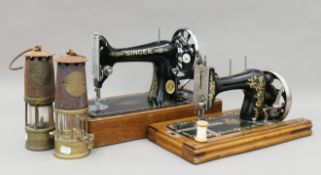 Two vintage miner's lamps, a cased Singer sewing machine and another sewing machine.