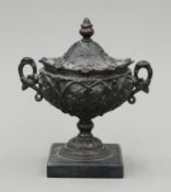 A small bronzed lidded urn on marble plinth base. 16 cm high.