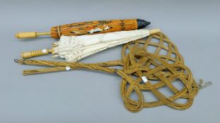 Two vintage carpet beaters and two parasols. The larger beater 80 cm long.