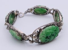 A five-panel jade, pearl and unmarked silver bracelet. 19 cm long, central panel 3.5 x 2 cm.