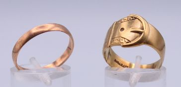 A 9 ct gold wedding band and a 9 ct gold buckle form ring. Ring sizes R and O. 5.5 grammes.